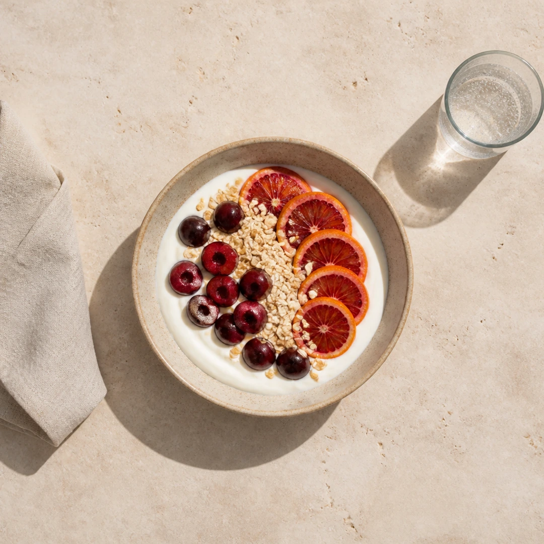 Overhead yogurt, fruit, linen, and sparkling water cropped into a square image
