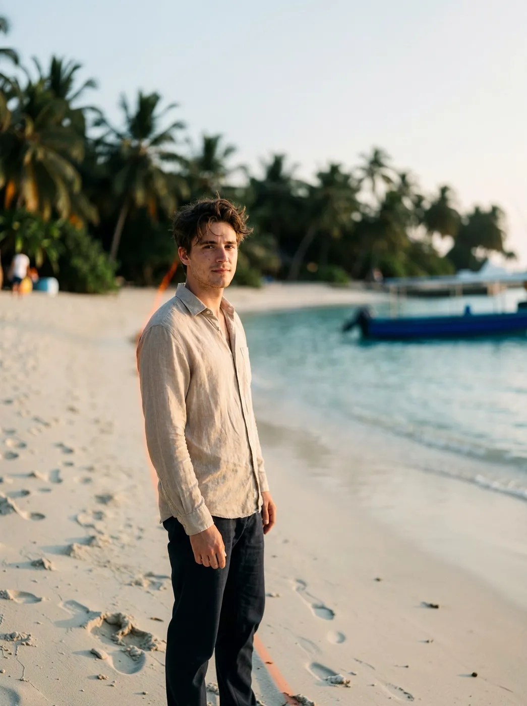 A beach portrait zoomed out 1.5× to reveal more sand, water, and palm trees
