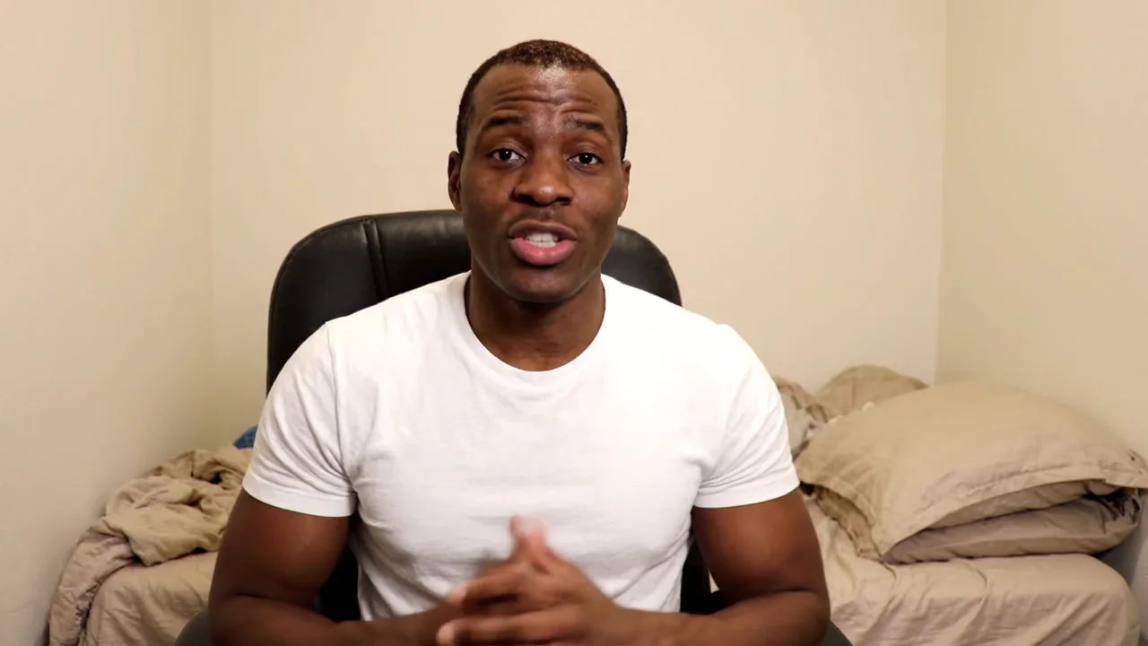 A man recording in a plain bedroom